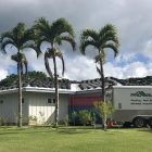 House under construction with palm trees and a ProBuilt Hawaii trailer.